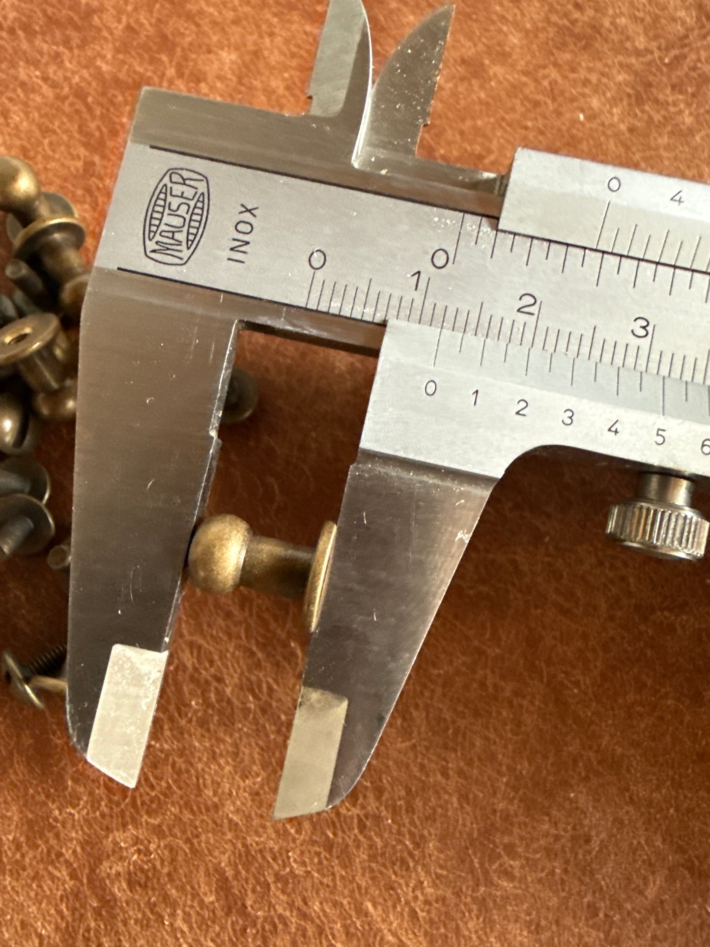Knopfniete Beiltaschenknopf 7/4mm mit Schraube M3x7mm. Gesamthöhe 12mm. Schafthöhe 6mm. Altmessing.