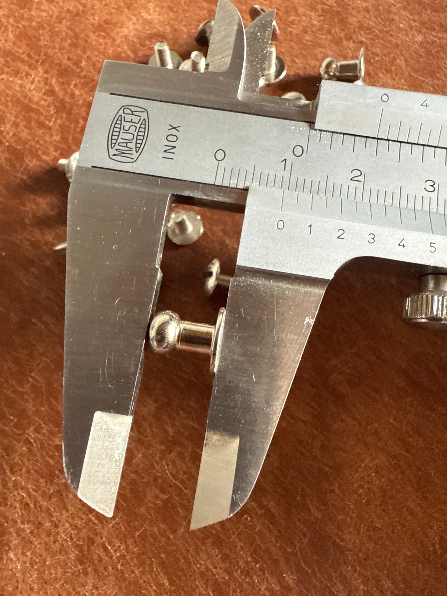 Knopfniete Beiltaschenknopf 6/4mm mit Schraube M3x6mm. Gesamthöhe 9,5mm. Schafthöhe 4,5mm. Messing vernickelt.