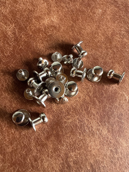Knopfniete Beiltaschenknopf 7/4mm mit Schraube M3x6mm. Gesamthöhe 10mm. Schafthöhe 4,5mm. Messing vernickelt.