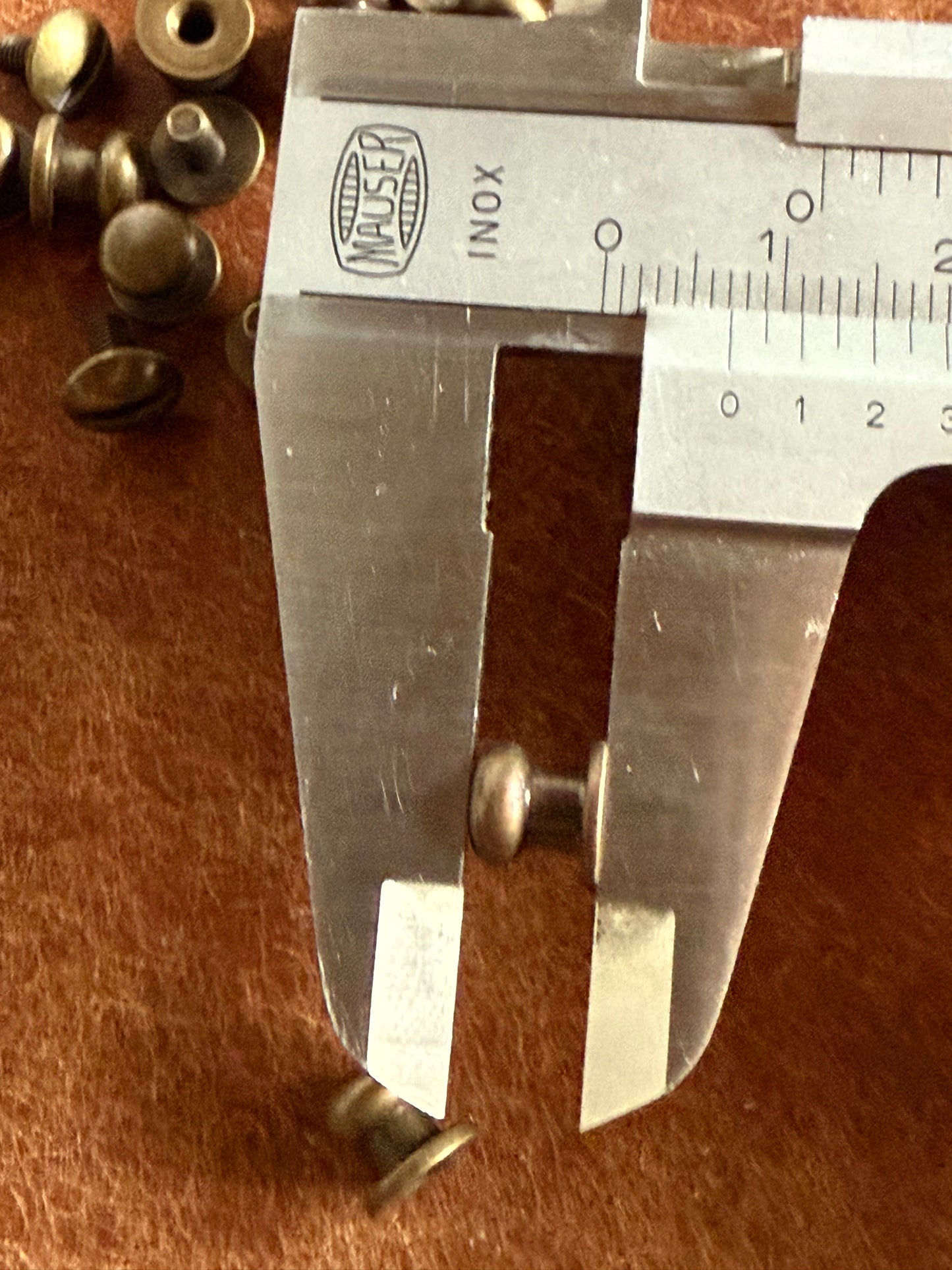 Knopfniete Beiltaschenknopf 6,5/4mm mit Schraube M3x6mm. Gesamthöhe 7mm. Schafthöhe ca. 3mm. Altmessing.